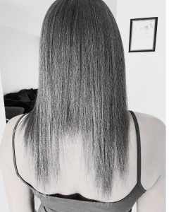 Back view of straightened hair showing a distinct H-shaped gap in the length caused by heat damage.