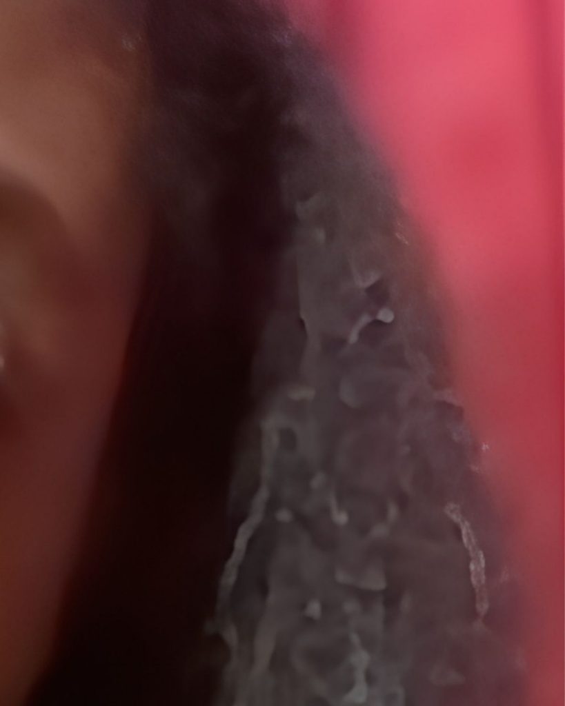 Natural hair beginning to revert after silk press due to environmental moisture.